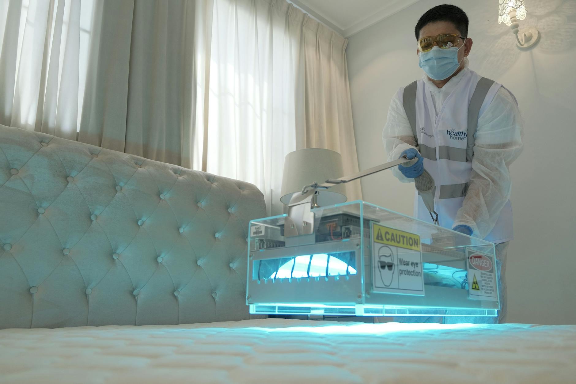 Rooftop Exterminating technician treating a mattress during a bed bug extermination